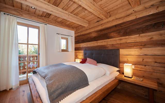 Gemütliche Schlafzimmer mit hochwertigen Betten in charmanten Holzchalets