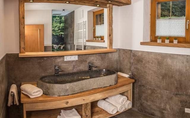 Badezimmer mit Doppelwaschbecken, Dusche und separaten WCs