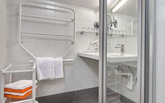 Spacious bathroom with shower, sink and towel warmer