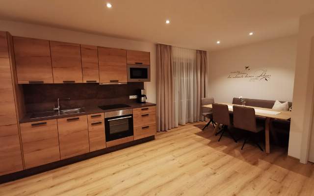 Spacious kitchen-living room with dining table and balcony