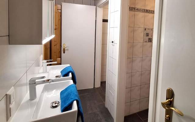 Badezimmer mit Doppelwaschbecken, WC und Dusche