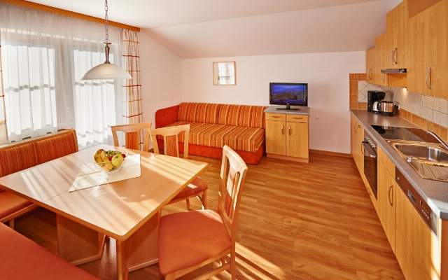 Large kitchen-living room with flat screen TV and balcony