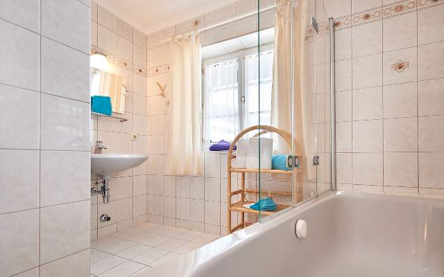 Badezimmer mit Waschbecken, Dusche, WC und Badewanne